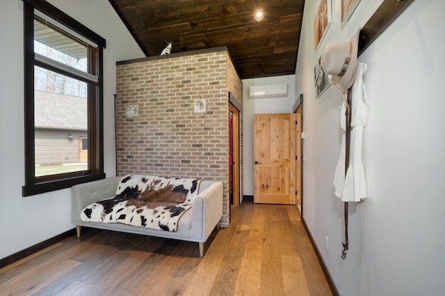 interior space featuring lofted ceiling, a wall mounted AC, wooden ceiling, baseboards, and light wood-style floors