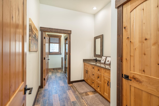 full bathroom featuring wood finished floors, a stall shower, baseboards, vanity, and recessed lighting