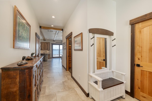 hall featuring baseboards, visible vents, and recessed lighting