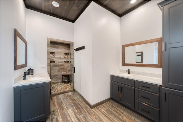 full bathroom featuring vanity, recessed lighting, wood tiled floor, baseboards, and a tile shower