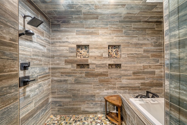 bathroom featuring a bath and tiled shower