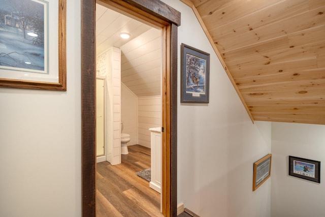 hall with lofted ceiling, light wood finished floors, and wood ceiling
