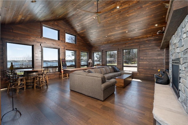 living area featuring wood walls, a fireplace, hardwood / wood-style floors, and high vaulted ceiling