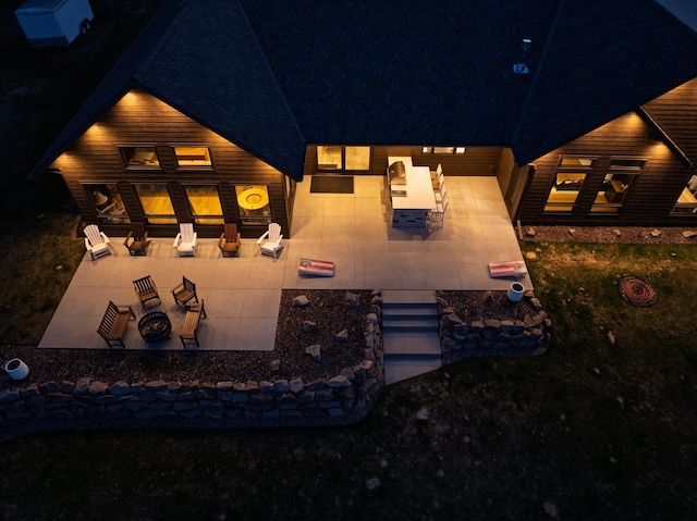 view of front of home featuring an outdoor fire pit, a patio area, and roof with shingles