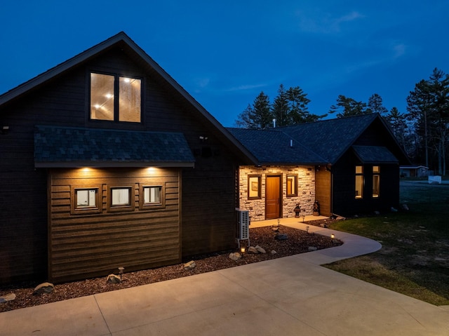 view of front of property featuring roof with shingles and a front yard