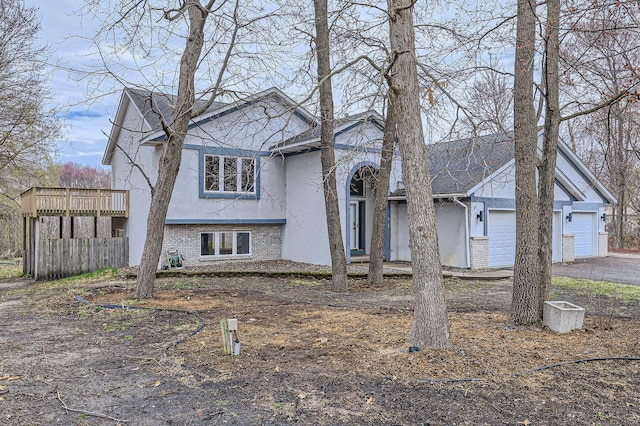 view of front of property with a garage, stucco siding, and brick siding