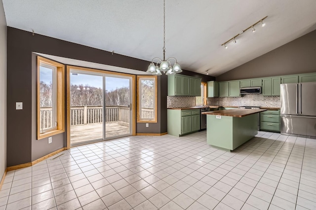 kitchen featuring butcher block counters, lofted ceiling, green cabinetry, a notable chandelier, and stainless steel appliances