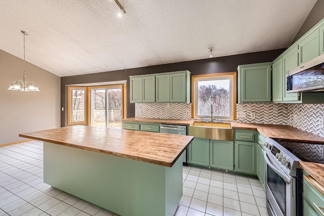 kitchen with a sink, appliances with stainless steel finishes, green cabinets, and butcher block countertops