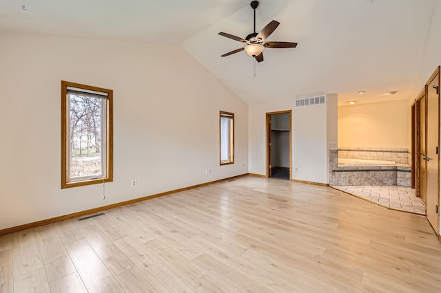 unfurnished bedroom with visible vents, light wood-style flooring, ensuite bath, and a spacious closet