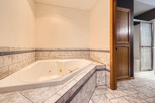 bathroom featuring a shower stall and a tub with jets