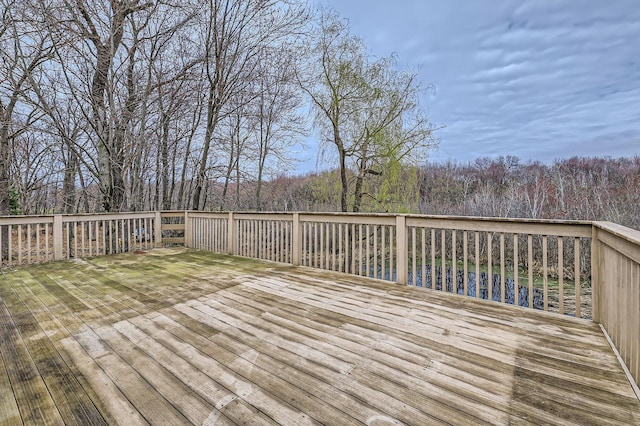 wooden terrace featuring a wooded view