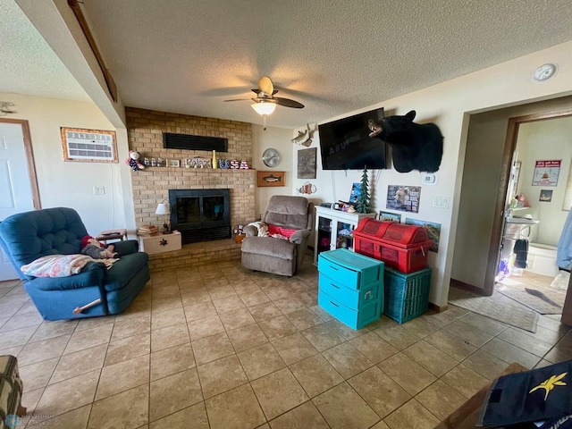 living area with ceiling fan, a textured ceiling, tile patterned flooring, and a brick fireplace