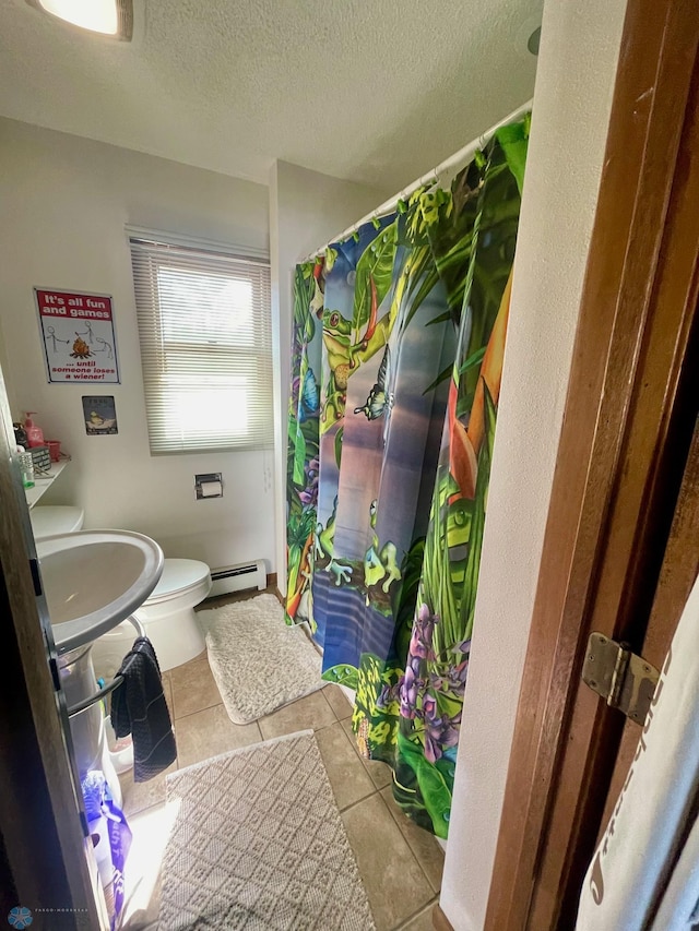 full bath with tile patterned flooring, baseboard heating, a shower with shower curtain, toilet, and a textured ceiling
