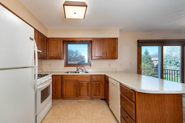 1540 Peggy Ln, North Mankato, MN 56003 - kitchen with a sink, white appliances, brown cabinetry, a peninsula, and light countertops