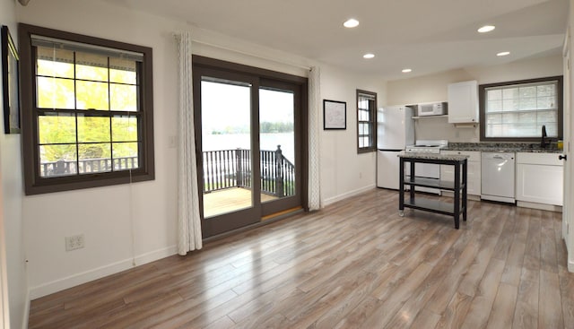 kitchen with white appliances, white cabinetry, recessed lighting, and light wood-style flooring