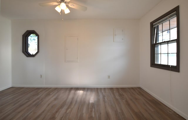 empty room with baseboards, a ceiling fan, and wood finished floors