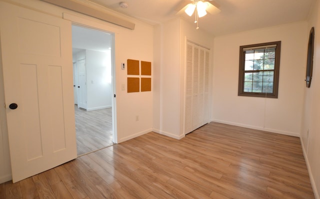 unfurnished room featuring light wood-style floors, baseboards, and ceiling fan
