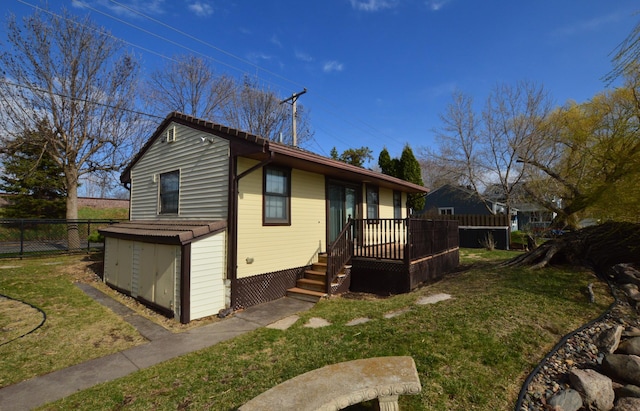 view of front of property with fence, a front yard, and a deck