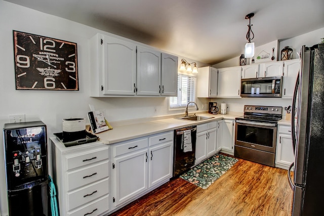 32290 US-71, Menahga, MN 56464 - kitchen featuring black appliances, a sink, wood finished floors, vaulted ceiling, and white cabinetry