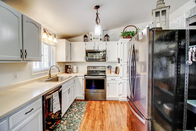 32290 US-71, Menahga, MN 56464 - kitchen with stainless steel appliances, a sink, vaulted ceiling, light wood-type flooring, and light countertops