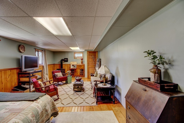 32290 US-71, Menahga, MN 56464 - bedroom with a wood stove, hardwood / wood-style floors, a wainscoted wall, a paneled ceiling, and wood walls