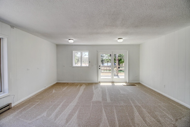32290 US-71, Menahga, MN 56464 - carpeted spare room featuring a textured ceiling, baseboards, and a baseboard radiator