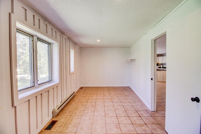 32290 US-71, Menahga, MN 56464 - empty room with baseboard heating, light tile patterned floors, and a textured ceiling