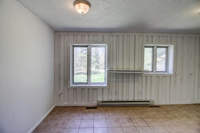 32290 US-71, Menahga, MN 56464 - empty room featuring a baseboard radiator, plenty of natural light, a textured ceiling, baseboards, and light tile patterned flooring
