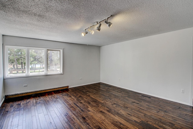 32290 US-71, Menahga, MN 56464 - unfurnished room with a baseboard heating unit, dark wood-type flooring, rail lighting, a textured ceiling, and baseboards