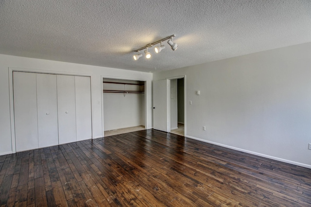 32290 US-71, Menahga, MN 56464 - unfurnished bedroom featuring two closets, wood-type flooring, and a textured ceiling