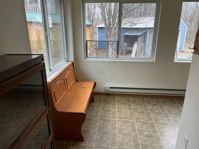 unfurnished room featuring baseboards, plenty of natural light, and a baseboard heating unit