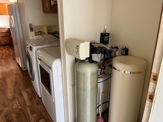 clothes washing area with laundry area, washing machine and dryer, and dark wood-type flooring