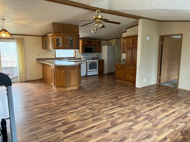 kitchen featuring white appliances, a peninsula, a textured ceiling, and dark wood-style floors