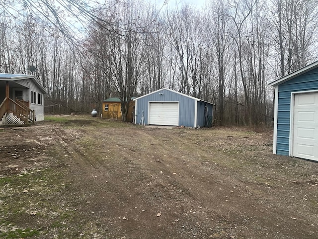 view of yard featuring an outbuilding, driveway, and a detached garage