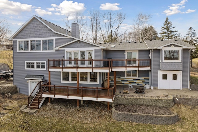 rear view of house with a patio, an outdoor fire pit, a wooden deck, and a chimney