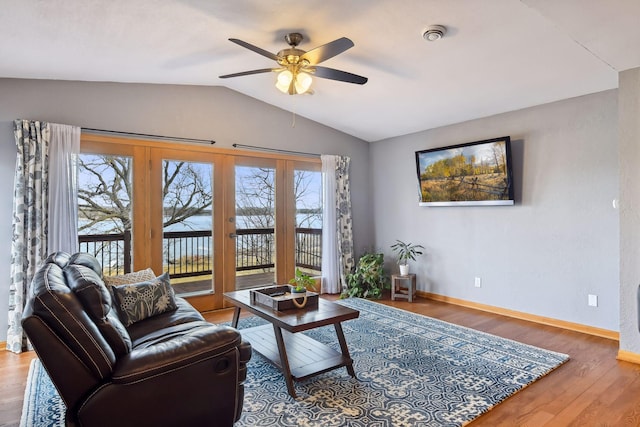 living area with vaulted ceiling, baseboards, a ceiling fan, and wood finished floors