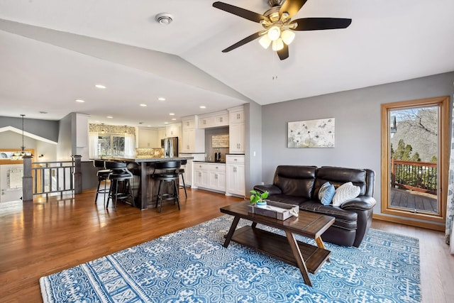 living area with a ceiling fan, vaulted ceiling, recessed lighting, and dark wood-type flooring