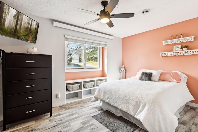 bedroom with baseboards, light wood-style flooring, and ceiling fan