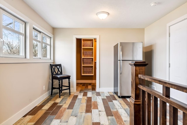 kitchen with baseboards, freestanding refrigerator, and wood finished floors