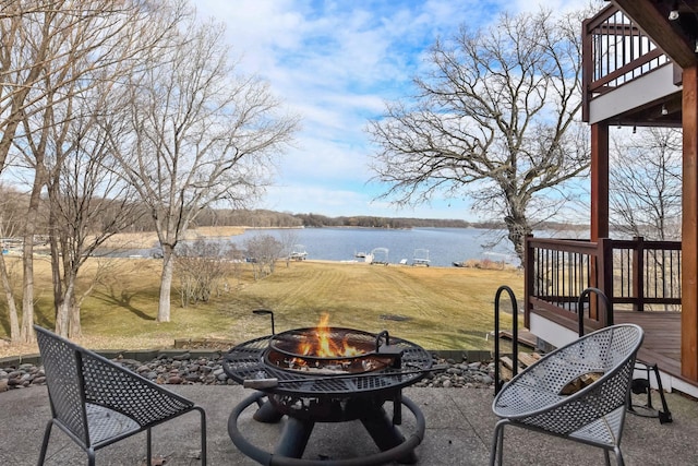 view of patio featuring an outdoor fire pit and a deck with water view