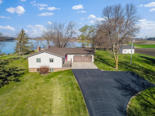 19447 County Road 1, Morris, MN 56267 - view of front of home featuring asphalt driveway, a front yard, a chimney, a water view, and an attached garage