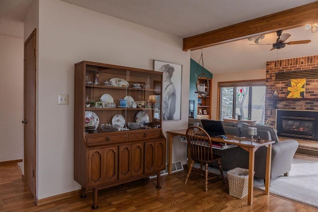 19447 County Road 1, Morris, MN 56267 - interior space with a brick fireplace, wood finished floors, ceiling fan, and vaulted ceiling with beams