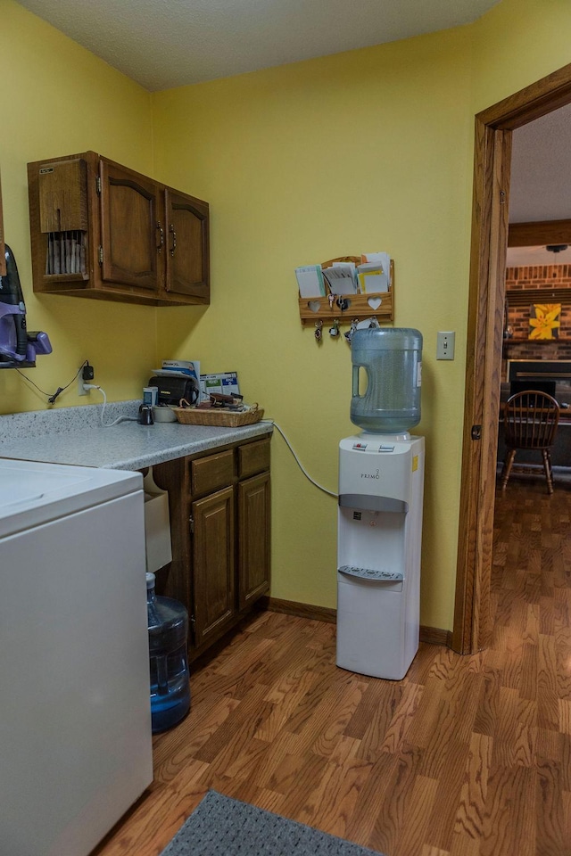 19447 County Road 1, Morris, MN 56267 - clothes washing area featuring baseboards, washer / clothes dryer, light wood-type flooring, and cabinet space