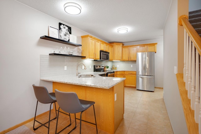 kitchen with stainless steel appliances, a sink, a peninsula, open shelves, and tasteful backsplash
