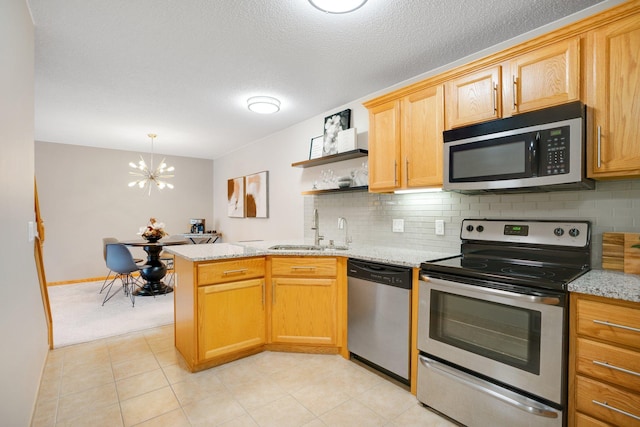 kitchen featuring stainless steel appliances, a sink, decorative backsplash, a chandelier, and open shelves