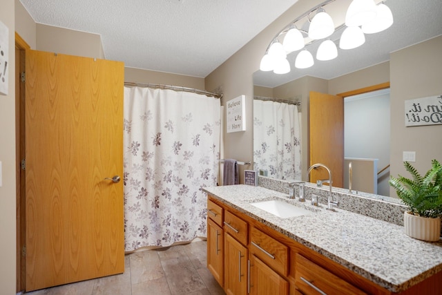 bathroom with vanity, curtained shower, and a textured ceiling