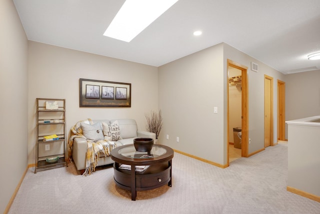living area featuring light colored carpet, a skylight, baseboards, and recessed lighting