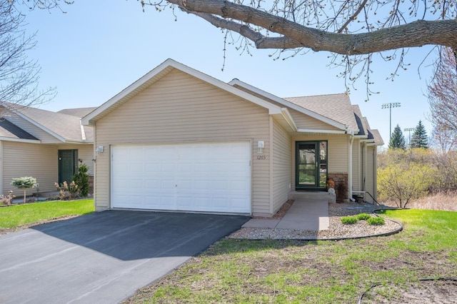 single story home with a garage, driveway, and a shingled roof