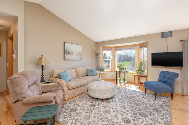 living room featuring baseboards, vaulted ceiling, and light wood-type flooring