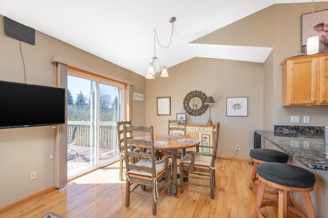 dining area featuring vaulted ceiling and light wood-style floors
